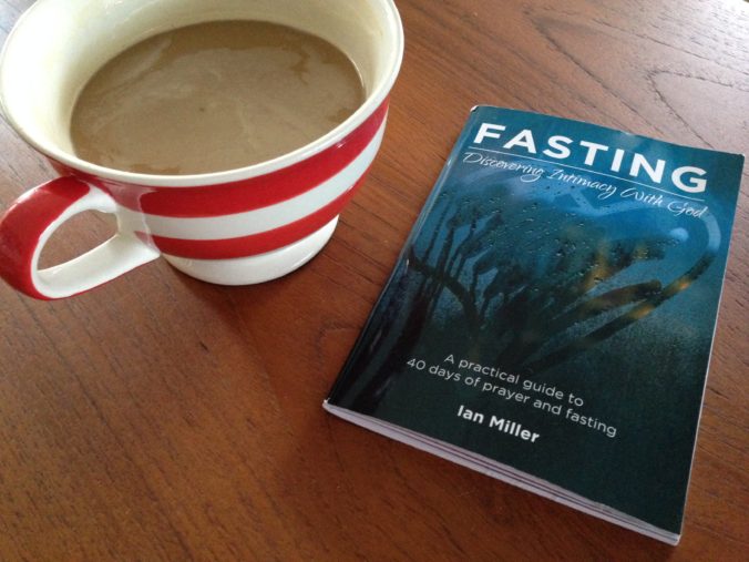 Coffee and a copy of Fasting: Discovering Intimacy With God by Ian Miller